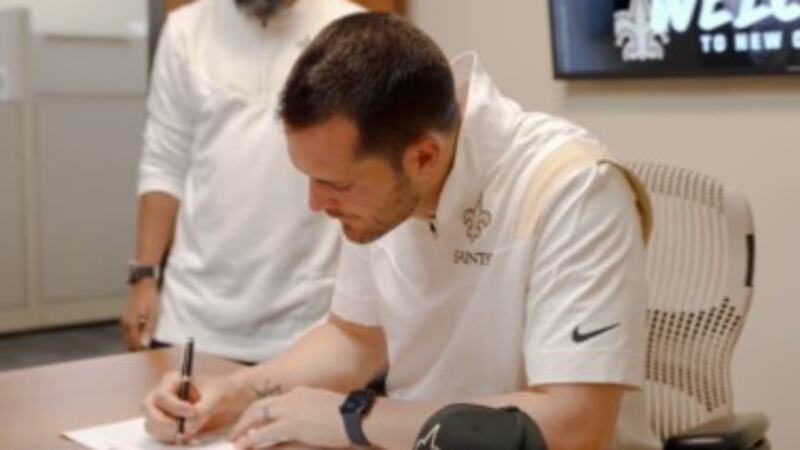 Quarterback Derek Carr signs his four-year contract with the Saints at the team's facility in...