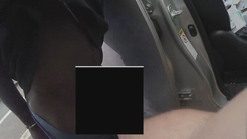 A still picture from body camera video from BRPD shows a strip search in broad daylight.