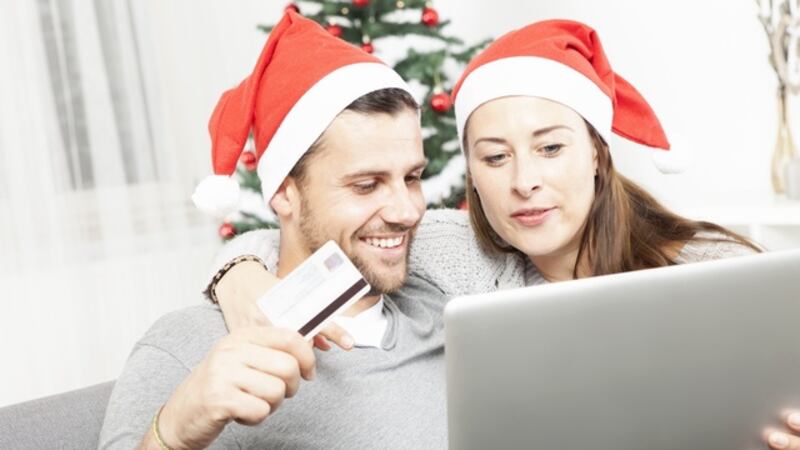 happy couple find perfect present gifts online on sofa indoors using credit card and laptop