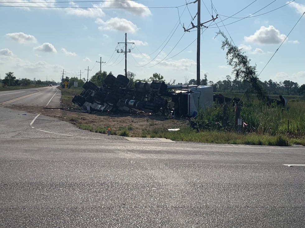 A photo from state police shows an 18-wheeler on its side next to the road.